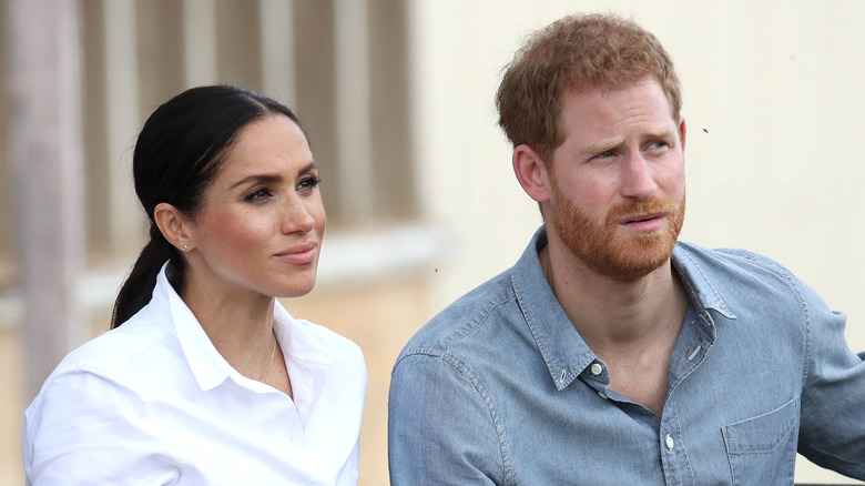 Meghan Markle and Prince Harry listening during an interview