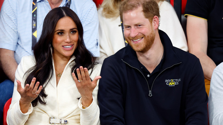 Meghan Markle explains something to Prince Harry