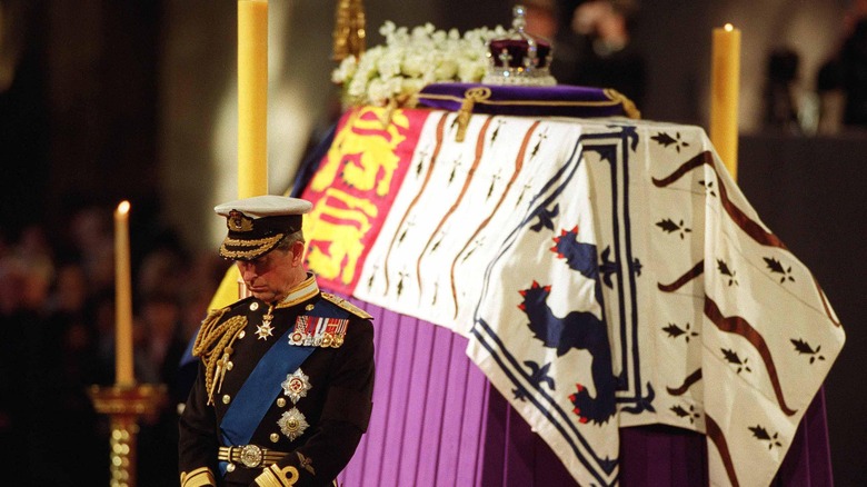 King Charles III standing in front of Queen Elizabeth II's coffin 