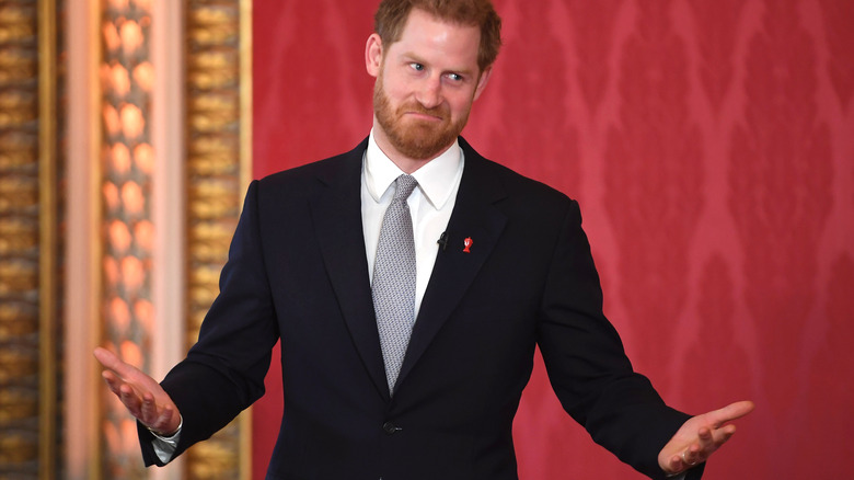 Prince Harry holding up his hands and making a face