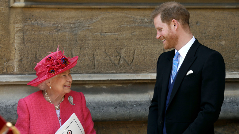 Queen Elizabeth and Prince Harry smiling at each other