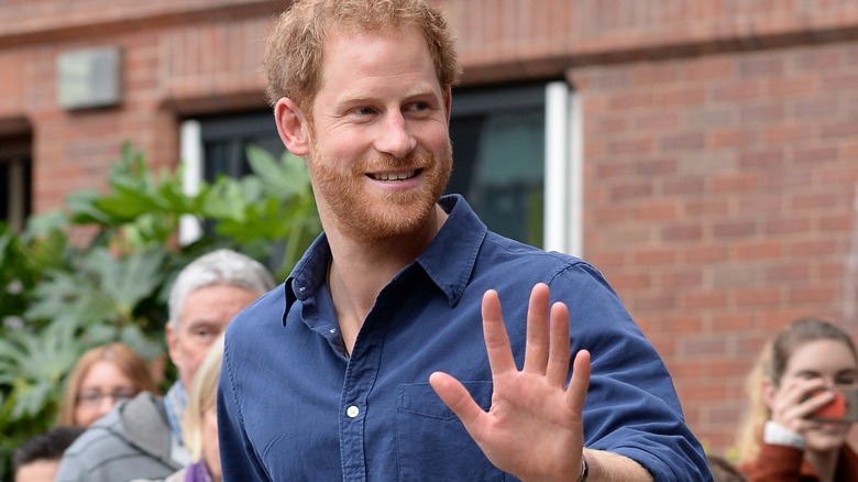 Smiling Prince Harry waves casually