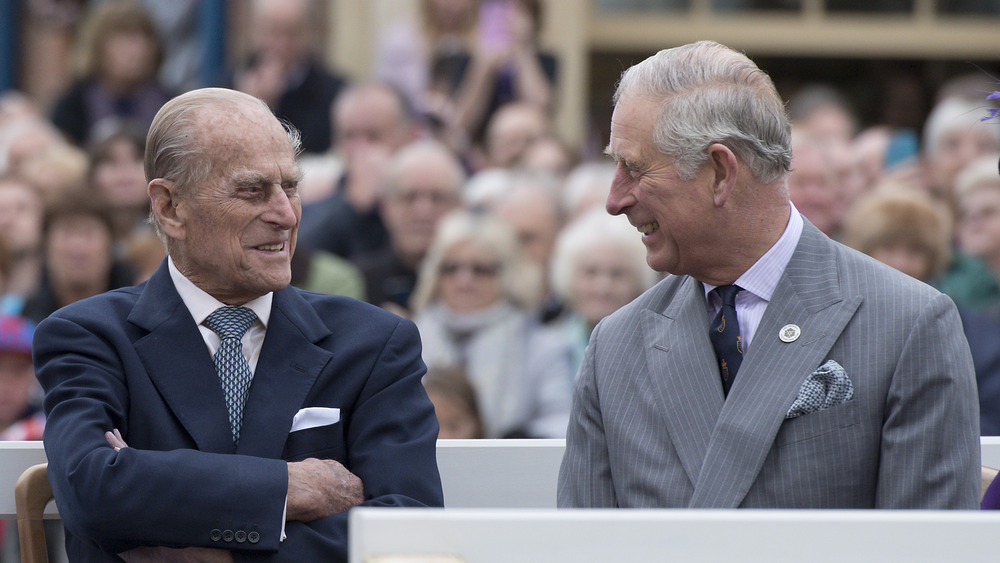 Prince Philip and Prince Charles smile at one another