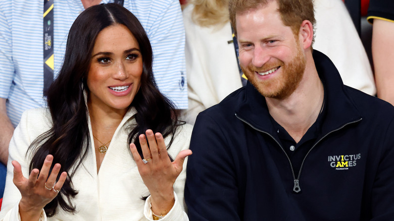 Meghan Markle hands up Prince Harry smile 