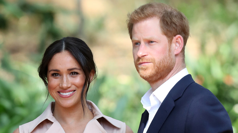 Meghan Markle and Prince Harry grinning for a camera