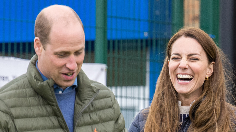 Prince William facing down and Kate Middleton laughing