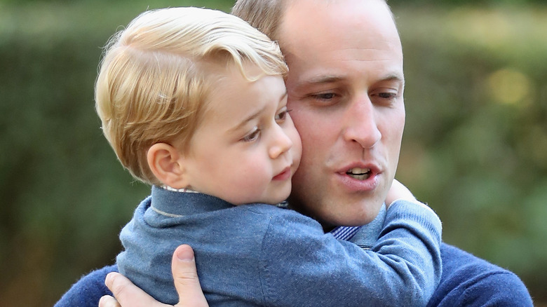 William cuddling George as toddler