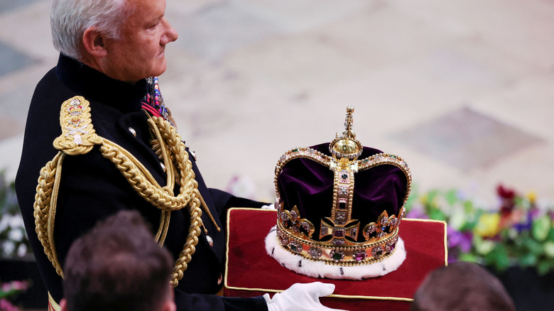 Man in suit handling crown jewels