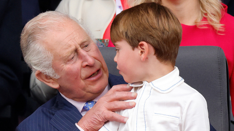 Prince Charles holds Prince Louis on his lap