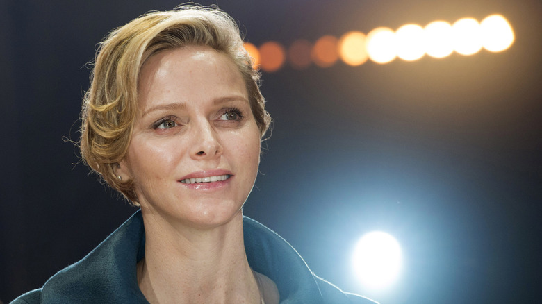 Princess Charlene smiling under spotlight