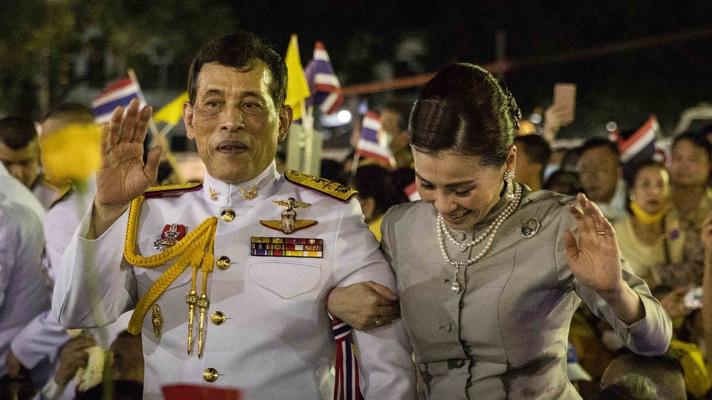 The King and Queen of Thailand waving to a crowd