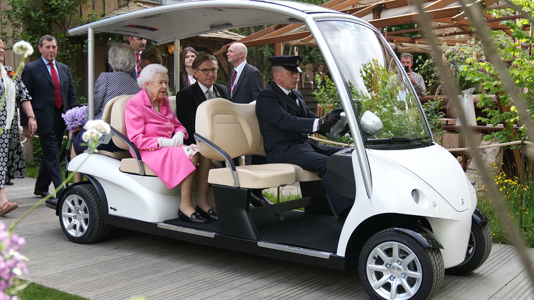 Queen Elizabeth riding in a golf cart