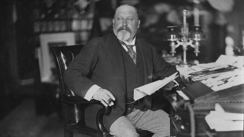 King Edward VII sitting at a desk