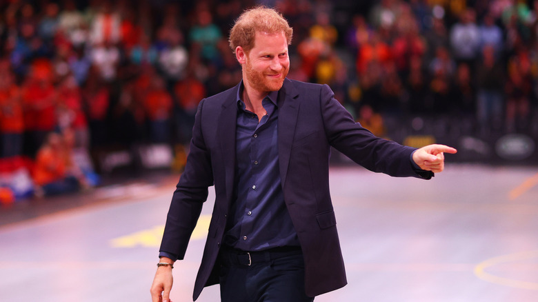 Prince Harry pointing to crowd smiling