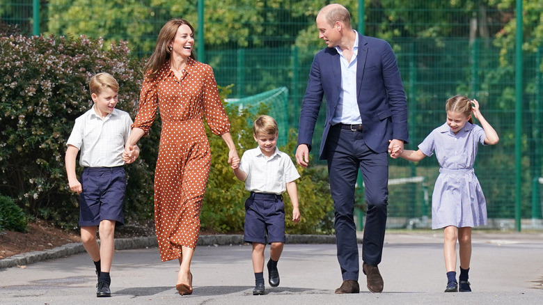 The Prince and Princess of Wales holding hands with Prince George, Princess Charlotte, and Prince Louis