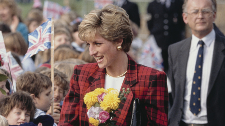 Princess Diana smiling and greeting a crowd of children