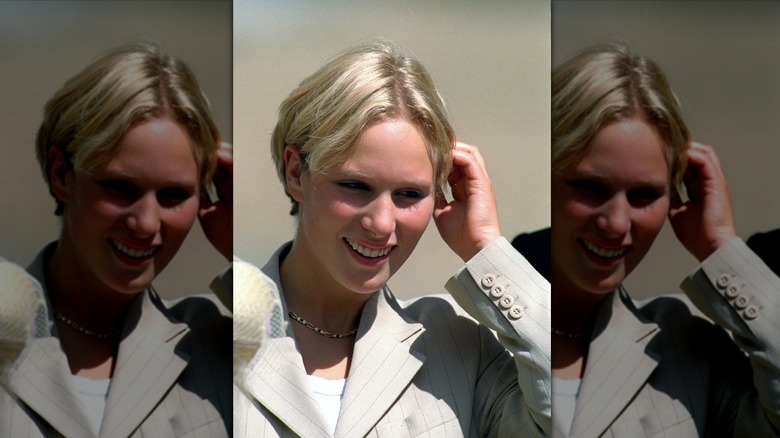 Teenage Zara Tindall smiling while tucking her hair back