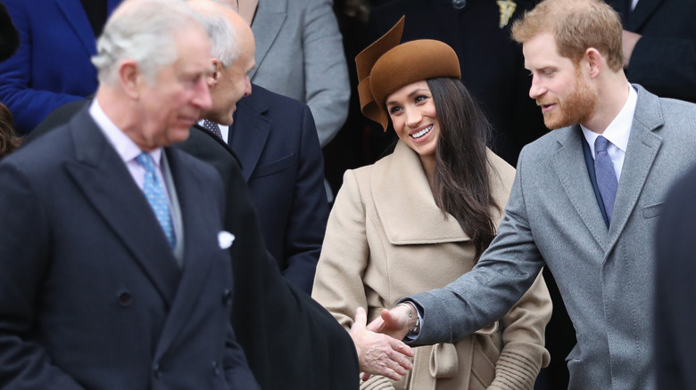 Meghan and Harry with Charles in the foreground 