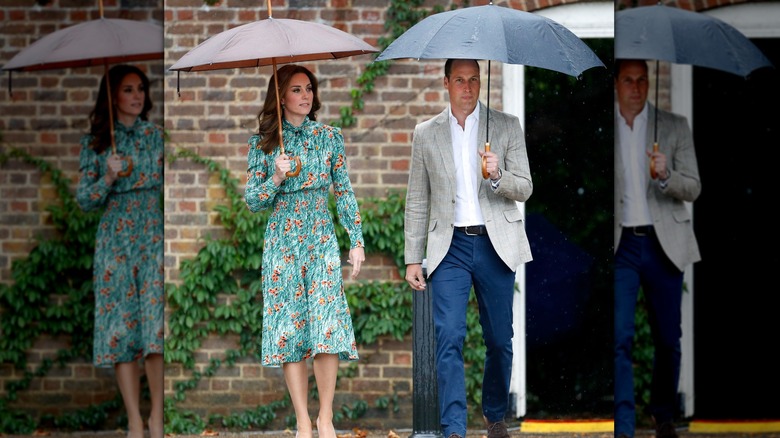 Princess Catherine and Prince William walking in the rain under umbrellas