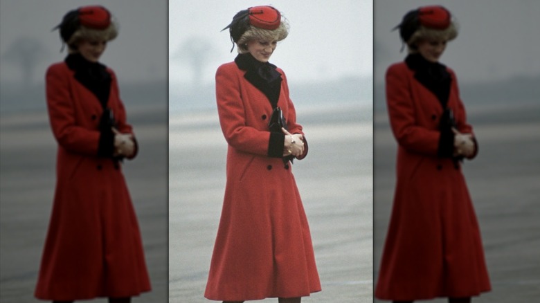 Princess Diana walking outside in red coat dress and matching hat