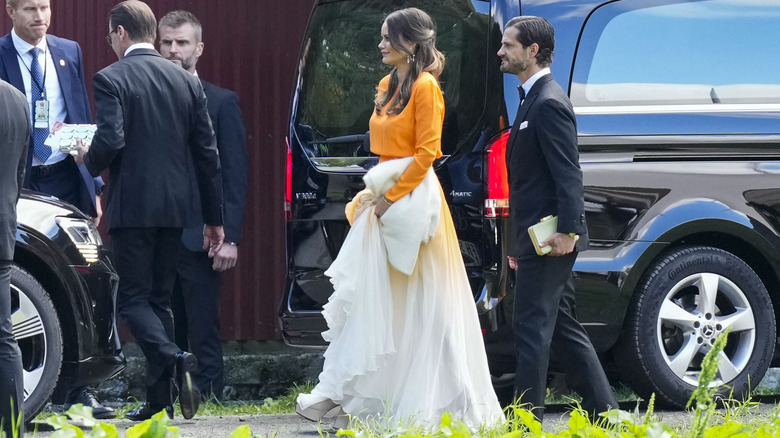 Princess Sofia and Prince Carl Philip dressed in formal attire walking past body guards