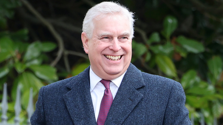 Prince Andrew grinning at memorial service