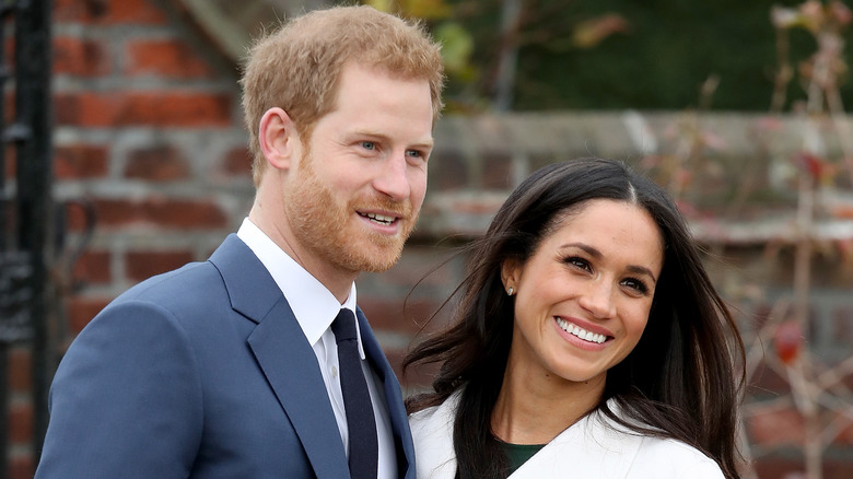 Prince Harry and Meghan Markle smiling at the camera