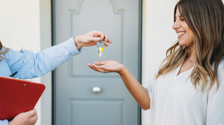 Real estate agent giving keys to woman