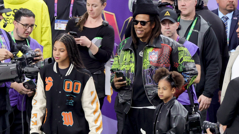 Jay-Z, Blue Ivy, and Rumi Carter on football field during Super Bowl