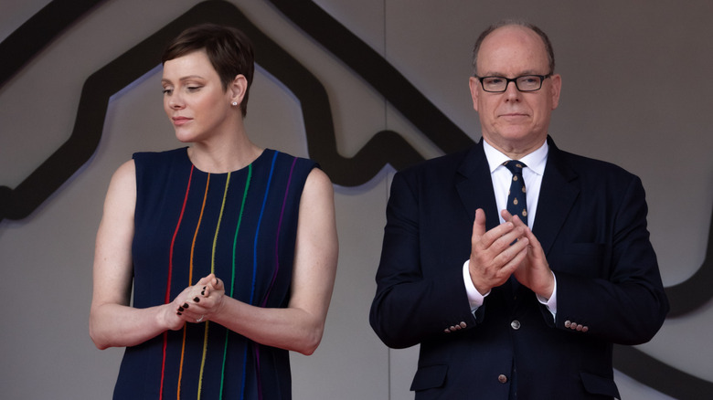 Prince Albert and Princess Charlene standing together and clapping