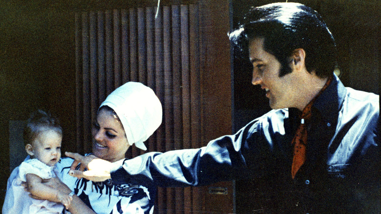 Priscilla Presley holding Lisa Marie Elvis pointing