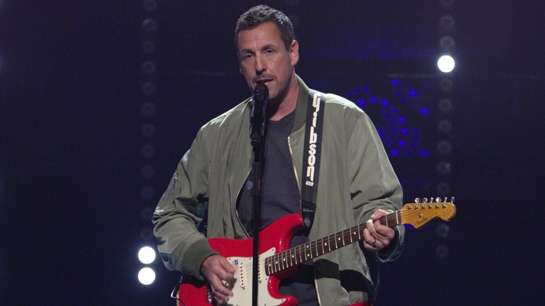 Adam Sandler playing guitar singing