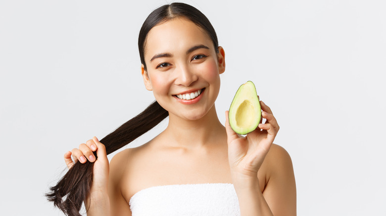 Woman with dark hair and avocado 