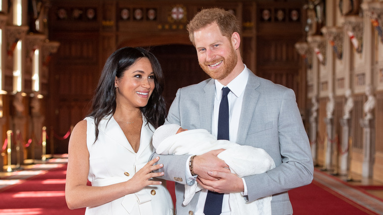 Meghan Markle and Prince Harry pose with their baby