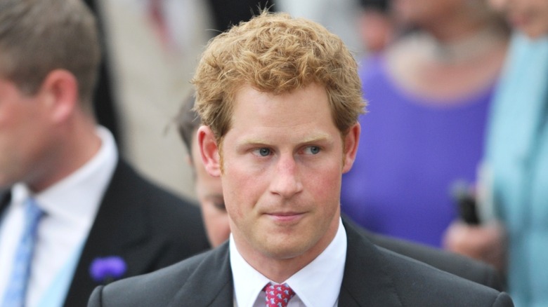 Prince Harry looking somber in a dark suit