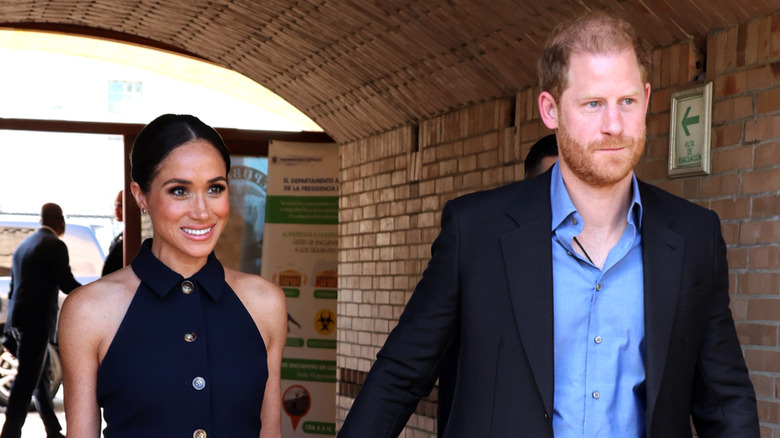 Meghan Markle and Prince Harry walking while holding hands