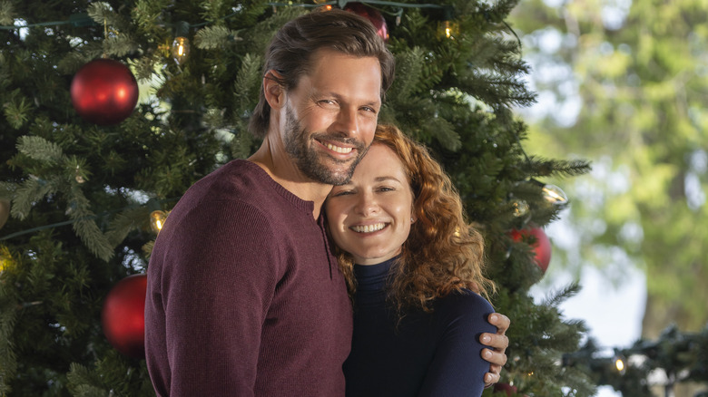 Justin Bruening and Sarah Drew in front of Christmas tree