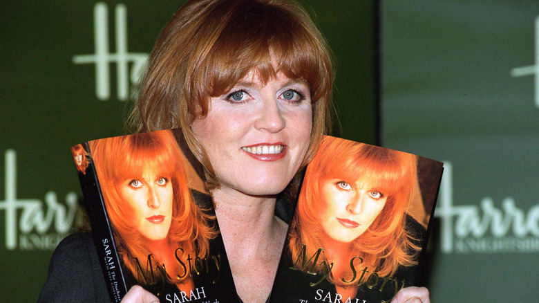 Sarah Ferguson holds up copies of her book