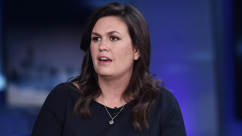 Sarah Sanders in a black dress speaking on Fox News