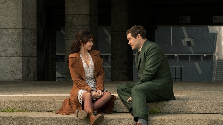 Sarah Hyland and Adam Devine sitting on steps