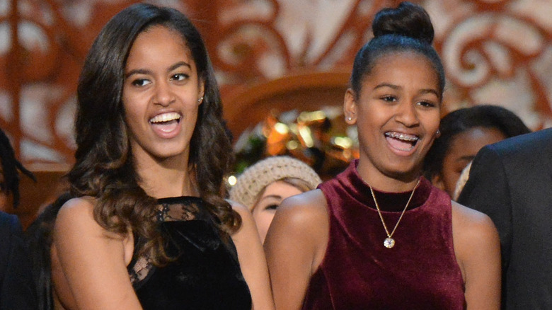 Malia and Sasha Obama laughing at event