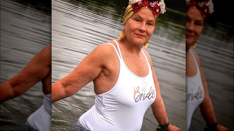 Woman wearing flower swim cap and white bride swimsuit