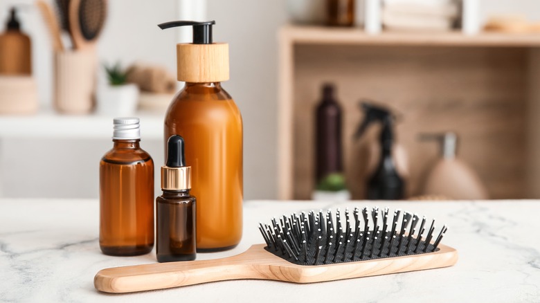 Bottles of hair oil products and brush