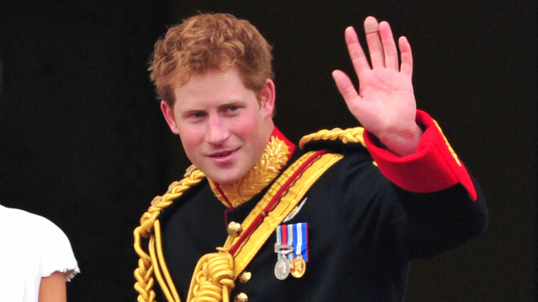 Prince Harry waves to fans at Buckingham Palace in April 2011