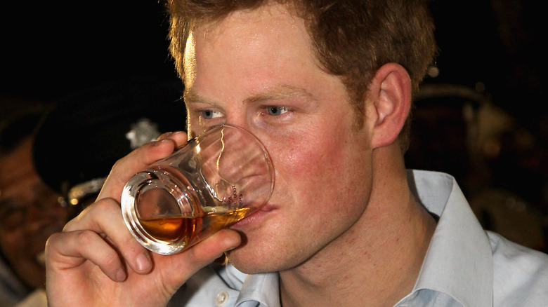 Prince Harry enjoys a drink at a party in Belize in 2012