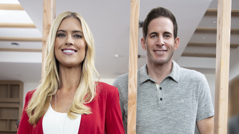 Christina Hall and Tarek El Moussa posing in a construction zone