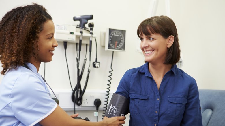 A doctor taking a woman's blood pressure