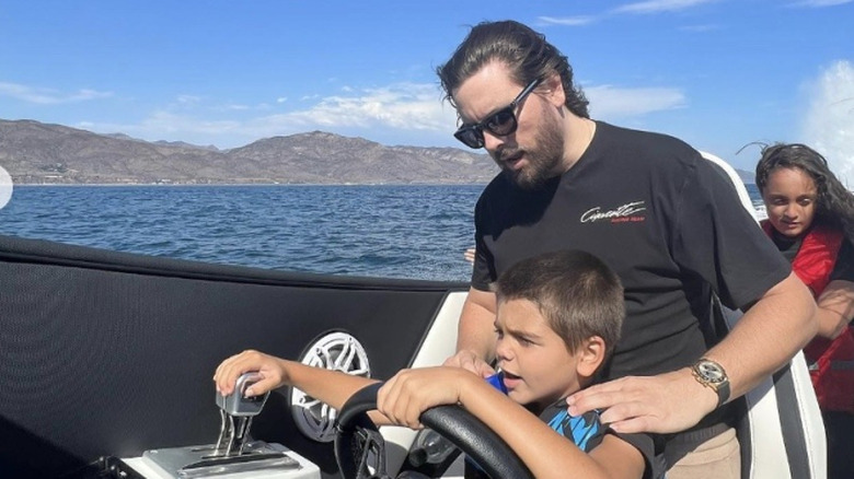 Scott and Mason Disick driving a boat.