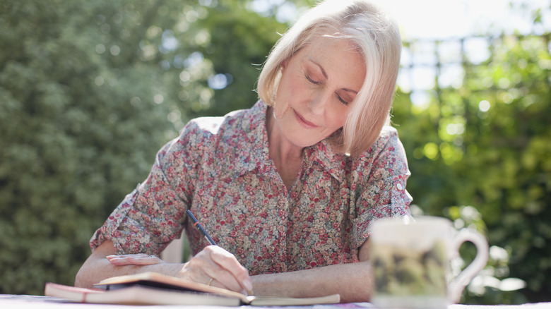 A woman writing in notebook