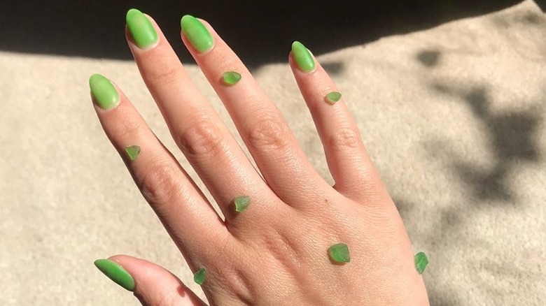 Hand with green sea glass manicure